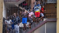 Warga dari lingkungan Hillbrow yang padat penduduk di pusat kota Johannesburg, di karantina sebagai upaya pencegahan penyebaran virus Corona, mereka berdiri di tangga. Afrika Selatan melakukan lockdown nasional selama 21 hari dalam upaya mengurangi penyebaran COVID-19. AP Photo/Jerome Delay.
