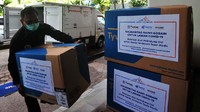 Karyawan Saint Gobain Group mengangkat APD (Alat Pelindung Diri) yang akan diserahkan kepada Suku Dinas Kesehatan Kota Administrasi Jakarta Selatan di Jakarta, Kamis (2/4/2020).  Foto: Istimewa.  