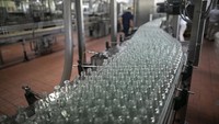 Botol-botol alkohol antiseptik ini bergerak di sepanjang jalur perakitan di pabrik rum Santa Teresa di La Victoria, negara bagian Aragua, Venezuela, Rabu (1/4/2020).