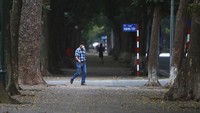 Dengan cara yang murah, Vietnam bisa dibilang berhasil melawan Corona karena kedisiplinan masyarakatnya yang ikut mentaati keputusan pemerintah. Seorang pria dengan memakai masker berjalan, di jalan yang terlihat sepi, di Hanoi, Vietnam.
