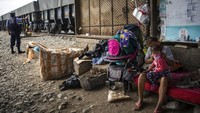 Seorang ibu mengenakan masker wajah pelindung kepada putrinya di daerah tempat mereka tinggal, di samping rel kereta api di Lima, Peru. AP Photo/Rodrigo Abd.