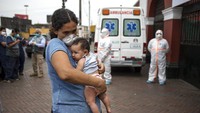 Warga Venezuela Maria de Los Angeles Mendez menggendong putrinya yang berusia 3 bulan, Maria, sambil menunggu untuk mengajukan permohonan perlindungan di Plaza de Toros de Acho di Lima, Peru, Selasa (31/3/2020). Pertempuran tertua di Amerika Latin telah dikonversi ke tempat penampungan bagi tunawisma sebagai langkah untuk membantu menahan penyebaran virus Corona. AP Photo/Rodrigo Abd.