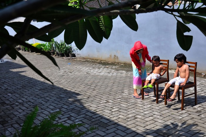 Seorang ibu menjemur kedua anaknya di bawah sinar matahari saat 'Self Isolation' atau tinggal di rumah di Medan, Sumatera Utara, Minggu (22/3/2020). Berjemur diri di bawah matahari di antara pukul 08.00 WIB-11.00 WIB merupakan salah satu upaya yang paling sederhana untuk menjaga kesehatan selama wabah virus COVID-19. ANTARA FOTO/Septianda Perdana/foc.