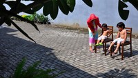 Seperti seorang ibu yang menjemur kedua anaknya di bawah sinar matahari pagi saat Self Isolation atau tinggal di rumah mereka masing-masing di Medan, Sumatera Utara. ANTARA FOTO/Septianda Perdana