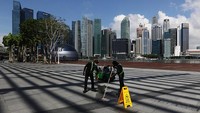Pekerja yang mengenakan topeng pelindung melakukan pekerjaan pemeliharaan di plaza acara Marina Bay Sands pada tanggal 1 April 2020 di Singapura. Untuk mencegah penyebaran corona, pemerintah juga menerapkan aturan wajib karantina di rumah terhadap warganya. Pemerintah tak segan menindak pelanggar yang nekat keluar rumah dengan ancaman pidana penjara. Suhaimi Abdullah/Getty Images.  