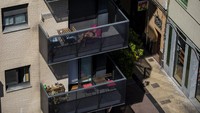 Beberapa warga di Spanyol memanfaatkan balkon pemukimannya untuk berjemur sambil bersantai di balkon rumah seperti di Barcelona, Spanyol ini. AP Photo/Emilio Morenatti