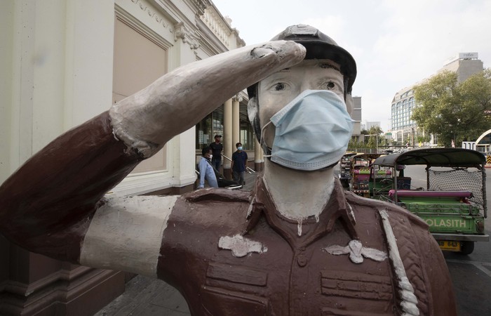 Virus corona yang melanda Thailand membuat warga selalu memakai masker saat beraktivitas di luar ruangan. Bahkan patung polisi di Bangkok ini ikut dipakaikan masker.