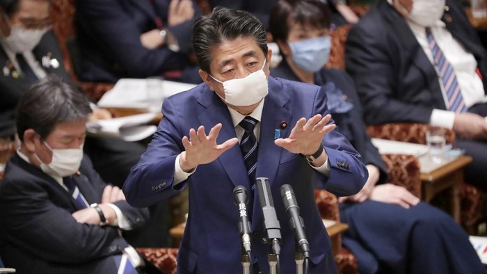Japans Prime Minister Shinzo Abe, wearing a face mask amid concerns over the spread of COVID-19 coronavirus, attends an upper house committee meeting at the parliament in Tokyo on April 1, 2020. (Photo by STR / JIJI PRESS / AFP) / Japan OUT