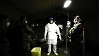Dokter berdiri di unit perawatan intensif selama latihan di rumah sakit lapangan militer di Mulhouse, Perancis Timur, Selasa 24 Maret 2020. Pihak militer Perancis membangun rumah sakit darurat untuk antispasi lonjakan pasein COVID-19. Mathieu Cugnot, Pool via AP.