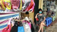 Setelah dinyatakan melewati masa karantina selama dua pekan, Kini pemilik toko Kim Anh duduk di sebelah gantungan tiang masker wajah yang memang dijajakkan untuk dijual, di kawasan Hanoi, Vietnam. Perdana Menteri Vietnam Nguyen Xuan Phuc telah memerintahkan untuk menutup bisnis yang tidak penting demi menghentikan penyebaran COVID-19. Inilah hasilnya. Vietnam berhasil menekan angka kasus COVID-19.