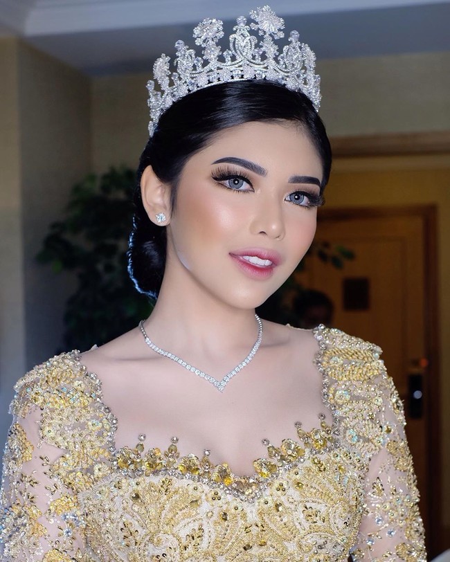 Rica juga terlihat bak princess di resepsi pernikahannya dengan Fahrul Sudiana. Dia memakai mahkota dari Rinaldy A. Yunardi. Penampilan memesonanya saat akad dan resepsi berkat makeup dari makeup artist langganan artis Bennu Sorumba. Foto: Instagram @bennusorumba