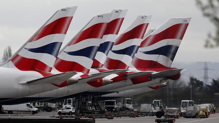 FILE - In this Wednesday, March 18, 2020 file photo, British Airways planes parked at Terminal 5 Heathrow airport in London. The airline has grounded much of its fleet and cabin crew, ground staff and engineers are among over 35,0000 employees facing job suspensions, it was reported on Thursday, April 2, 2020. For most people, the new coronavirus causes only mild or moderate symptoms, such as fever and cough. For some, especially older adults and people with existing health problems, it can cause more severe illness, including pneumonia. (AP Photo/Frank Augstein, File)