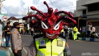 Berbagai cara dilakukan polisi di Kota Pasuruan untuk mengingatkan masyarakat akan bahaya virus corona. Salah satunya dengan membuat atraksi mengunakan helm menyerupai virus corona yang seram.