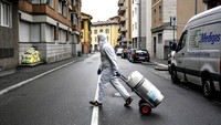 Petugas mengantar tabung oksigen ke pasien Corona yang dirawat di rumah, di Bergamo, Italia bagian utara, (31/3/2020). Bergamo merupakan daerah paling parah terpapar Corona. Claudio Furlan/LaPresse via AP.