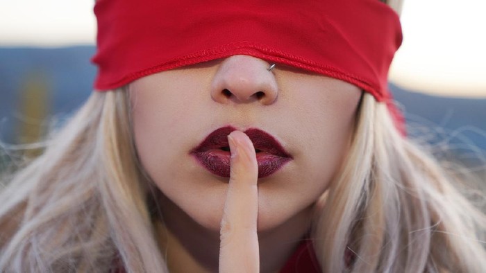 penutup mata beautiful sensual woman with silence symbol. Woman blindfolded with red cloth silence symbol