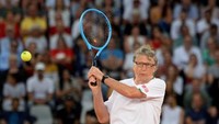 American philanthropist Bill Gates plays a return to Spains Rafael Nadal and South African Comedian Trevor Noah during their doubles tennis match at The Match in Africa at the Cape Town Stadium, in Cape Town on February 7, 2020. (Photo by RODGER BOSCH / AFP)
