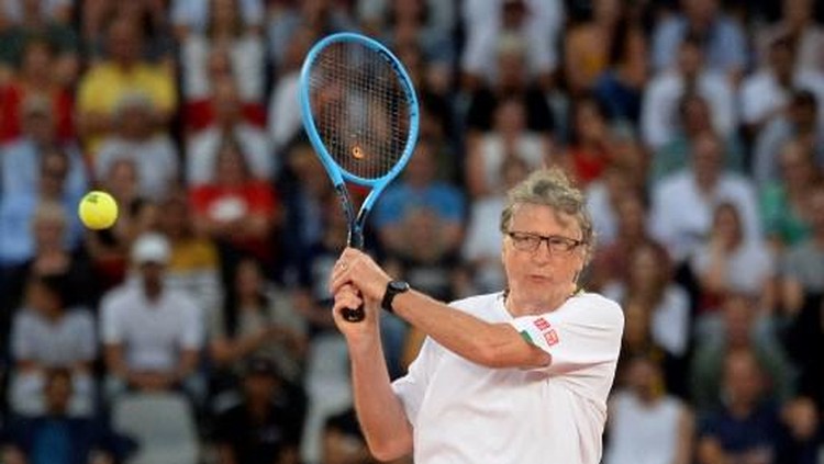 American philanthropist Bill Gates plays a return to Spains Rafael Nadal and South African Comedian Trevor Noah during their doubles tennis match at The Match in Africa at the Cape Town Stadium, in Cape Town on February 7, 2020. (Photo by RODGER BOSCH / AFP)