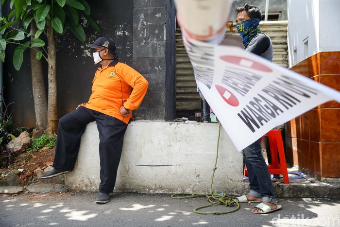 Warga berjaga di pintu masuk Kampung Perigi, Jalan Nimun Raya, Tanah Kusir, 
Kebayoran Lama Selatan, Jakarta, Kamis (3/4/2020). Grandyos Zafna/detikcom