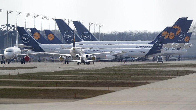 Lufthansa di Bandara Munich German Lufthansa planes sit parked in a line at the airport in Munich, Germany, Thursday, March 26, 2020. The planes are not in use because of the novel coronavirus outbreak. The new coronavirus causes mild or moderate symptoms for most people, but for some, especially older adults and people with existing health problems, it can cause more severe illness or death. (AP Photo/Matthias Schrader)