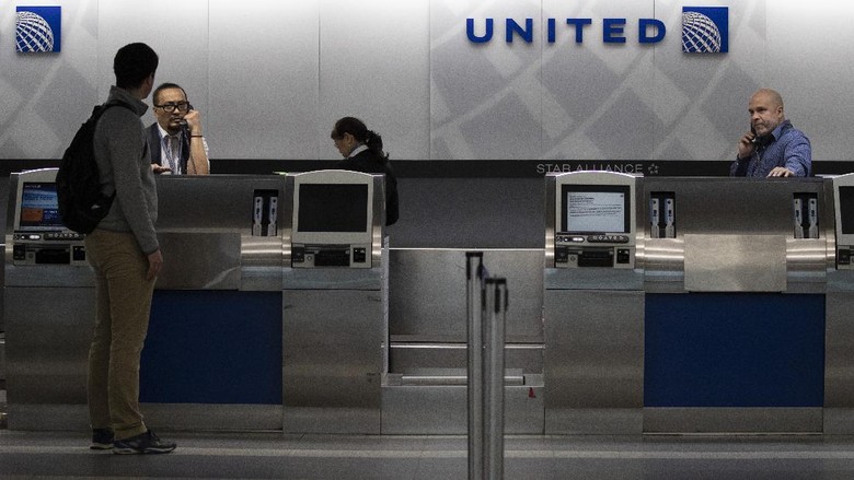 United Airlines di Bandara LaGuardia United Airlines employees help a passenger at LaGuardia Airport, Saturday, March 21, 2020, in New York, N.Y. The Federal Aviation Administration briefly suspended flights to New York City-area airports on Saturday after a trainee at a regional air-traffic control hub on Long Island tested positive for coronavirus. In an alert posted online, the FAA advised air traffic controllers to