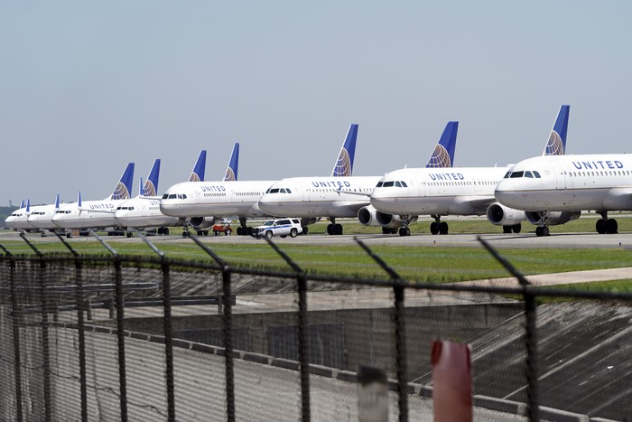 United Airlines planes are parked at George Bush Intercontinental Airport Wednesday, March 25, 2020. The airlines have reduced the number of flights flown each day as fewer people are flying due to the COVID-19 outbreak. The new coronavirus causes mild or moderate symptoms for most people, but for some, especially older adults and people with existing health problems, it can cause more severe illness or death. (AP Photo/David J. Phillip)