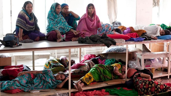 Pekerja Garmen di Bangladesh DHAKA, BANGLADESH - AUGUST 4: Women rest while participating in a hunger strike at a Tuba Group factory August 4, 2014 in Dhaka, Bangladesh. Garment workers have been on a hunger strike since July 28th, demanding three months of unpaid wages and Eid bonus from their employer, Tuba Group. (Photo by Allison Joyce/Getty Images)