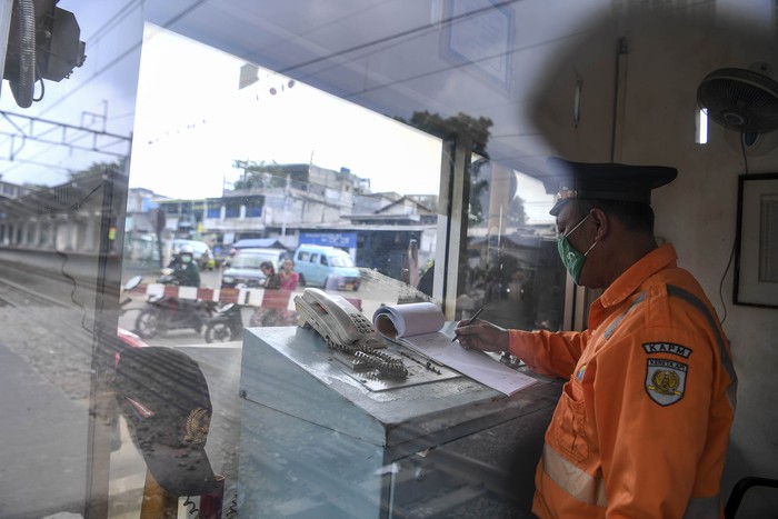 Petugas penjaga palang pintu kereta api Dedi (44) melakukan aktivitas kerja dari ruangannya di Jakarta, Sabtu (4/4/2020). Sejumlah warga masih melakukan aktivitas kerja di luar rumah seperti biasanya meski di saat pandemi COVID-19 agar tetap memberikan pelayanan kepada warga. ANTARA FOTO/Hafidz Mubarak A/hp.