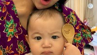 Sebelum makan, Thania pose dulu sama sang bunda. Ia memasang wajah serius meski sambil memegang sendok kayu yang lucu. Foto: Instagram