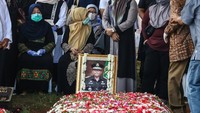 Kerabat memegang foto Almarhum Wakil Jaksa Agung Arminsyah saat jenazah dimakamkan.