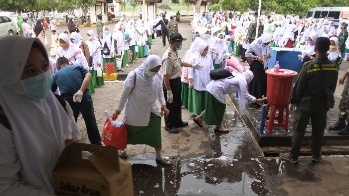 Sejumlah santri calon penumpang antre mencuci tangan sebelum memasuki KMP Dharma Bahari Sumekar III di area Pelabuhan Jangkar, Situbondo, Jawa Timur, Sabtu (4/4/2020). Kantor Kesyahbandaran dan Otoritas Pelabuhan (KSOP) Kelas IV Panarukan dan Pemkab Sumenep memfasilitasi pemulangan santri pondok pesantren sebanyak 566 orang asal Pulau Kangean, sebagai upaya pencegahan penyebaran COVID-19. ANTARA FOTO/Seno/hp.