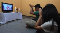 Keluarga umat Katolik mengikuti Misa Minggu Palma melalui media daring di Sawit, Boyolali, Jawa Tengah, Sabtu (4/4/2020).