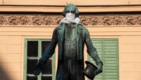 Selanjutnya ada patung seorang penyanyi Johann Nestroy di kota Vienna Austria yang dikenakan masker oleh warga, Saat ini terkonfirmasi Austria memilik kasus 12.000 pasien Positif Covid-19. Getty Images/Thomas Kronsteiner.