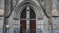 Petugas kebersihan melintas di depan pintu Gereja Katedral, Jakarta, Minggu (5/4/2020) kemarin. Semua kegiatan peribadatan di gereja tersebut yang mengumpulkan banyak orang untuk sementara waktu ditiadakan guna mencegah penyebaran virus Corona.