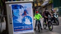Selanjutnya ada poster propaganda yang mengingatkan orang untuk mengambil perlindungan diri selama pandemi Coronavirus (COVID-19)  di Hanoi, Vietnam. Vietnam memulai kampanye untuk selalu menjaga jarak sosial selama masa darurat serta mengurangi kegiatan di luar rumah guna antisipasi penyebaran virus Corona. Getty Images/Linh Pham.