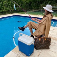 Tampaknya butuh hiburan, Lissy pun berpura-pura memancing di kolam renang pribadinya. Wanita itu membawa tas Louis Vuitton entah untuk apa. Foto: Instagram @lissygraham