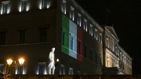 Bendera Italia diproyeksikan di gedung parlemen Yunani di belakang patung negarawan Yunani Eleftherios Venizelos, di Athena. Parlemen Yunani melakukan itu sebagai ungkapan solidaritas terhadap negara Italia yang menjadi salah satu negara yang paling parah terkena pandemi virus corona. AP Photo/Yorgos Karahalis.