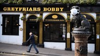 Momen patung Greyfriars Bobby yang memakai masker di wajahnya di Edinburgh, Skotlandia. Sekarang ada 5.683 kasus yang terdiagnosis di Inggris dan 281 kematian. Getty Images/Jeff J Mitchell.