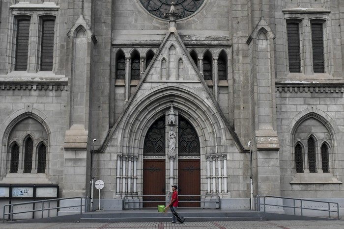 Petugas kebersihan melintas di depan pintu Gereja Katedral, Jakarta, Minggu (5/4/2020). Pasca Kemenkes resmi merilis Peraturan Menteri Kesehatan No.9 Tahun 2020 tentang Pembatasan Sosial Berskala besar (PSBB) dalam Rangka Percepatan Penanganan COVID-19, bentuk ibadah misa gereja dilakukan secara live streaming melalui media sosial, termasuk rangkaian ibadah paskah yang akan jatuh mulai Kamis (16/4/2020) hingga Minggu (19/4/2020). ANTARA FOTO/Muhammad Adimaja/foc.