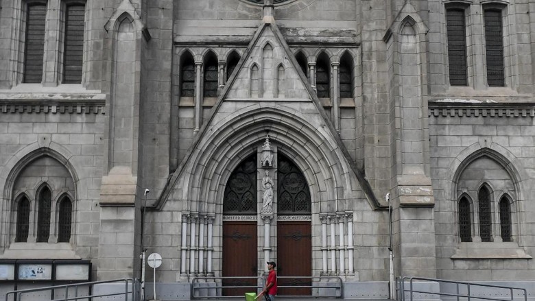 GEREJA DITUTUP Petugas kebersihan melintas di depan pintu Gereja Katedral, Jakarta, Minggu (5/4/2020). Pasca Kemenkes resmi merilis Peraturan Menteri Kesehatan No.9 Tahun 2020 tentang Pembatasan Sosial Berskala besar (PSBB) dalam Rangka Percepatan Penanganan COVID-19, bentuk ibadah misa gereja dilakukan secara live streaming melalui media sosial, termasuk rangkaian ibadah paskah yang akan jatuh mulai Kamis (16/4/2020) hingga Minggu (19/4/2020). ANTARA FOTO/Muhammad Adimaja/foc.