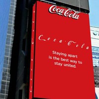 Memasang billboard besar di sebuah gedung di Times Square, New York, Coca Cola pun menjaga jarak setiap huruf pada logonya. Staying apart s the best way to stay united, pesan mereka. Foto: Istimewa
