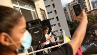 Seorang musisi Caracas, Venezuela bernama Zandu Montoya bernyanyi dari balkon rumahnya untuk menghibur diri dan teman-temannya selama karantina. (REUTERS/Manaure Quintero)