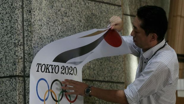 TOKYO, JAPAN - SEPTEMBER 01:  An employee removes a Tokyo 2020 Olympic poster showing the copied logo design hung at the entrance of the Tokyo Metropolitan Government Office building during an event staged for the media on September 1, 2015 in Tokyo, Japan. The 2020 Tokyo Olympics organizing committee announced after an emergency meeting that it will cease using the logo after it was found to have been plagiarized by designer Kenjiro Sano.  (Photo by Chris McGrath/Getty Images)