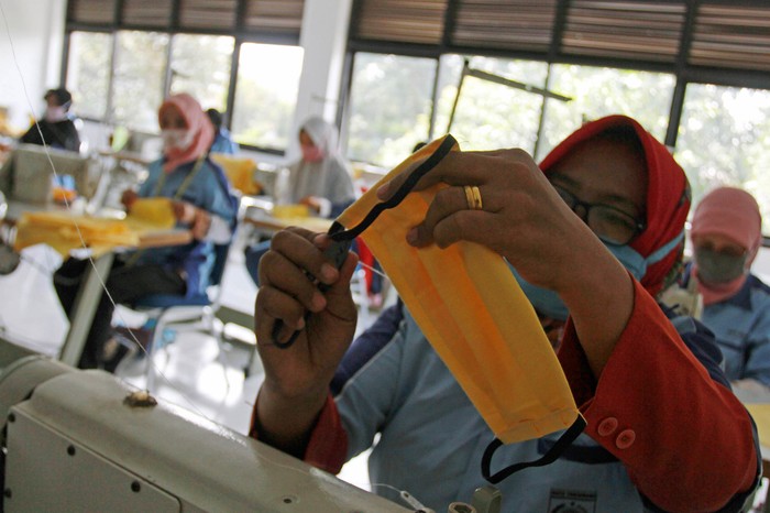 Relawan menunjukkan masker hasil produksinya di Gondangmanis, Kudus, Jawa Tengah, Senin (6/4/2020). Masker yang diproduksi dari bahan kain perca tersebut akan didistribusikan secara gratis kepada masyarakat yang membutuhkan guna mencegah penyebaran COVID-19. ANTARA FOTO/Yusuf Nugroho/wsj.