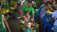 Cesar Alegre, ditemani sang putri yang berusia 4 tahun, mendorong keranjang berisi berbagai makanan yang tak laku dijual oleh pedagang di salah satu pasar yang berada di kawasan Lima, Peru.