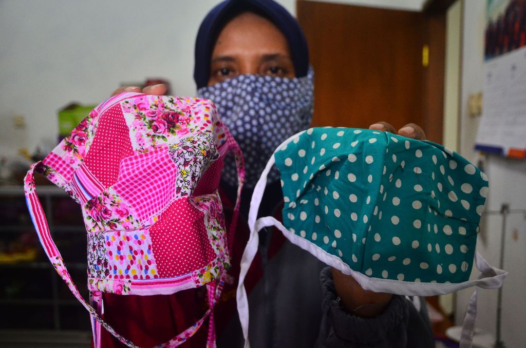 Relawan menunjukkan masker hasil produksinya di Gondangmanis, Kudus, Jawa Tengah, Senin (6/4/2020). Masker yang diproduksi dari bahan kain perca tersebut akan didistribusikan secara gratis kepada masyarakat yang membutuhkan guna mencegah penyebaran COVID-19. ANTARA FOTO/Yusuf Nugroho/wsj.