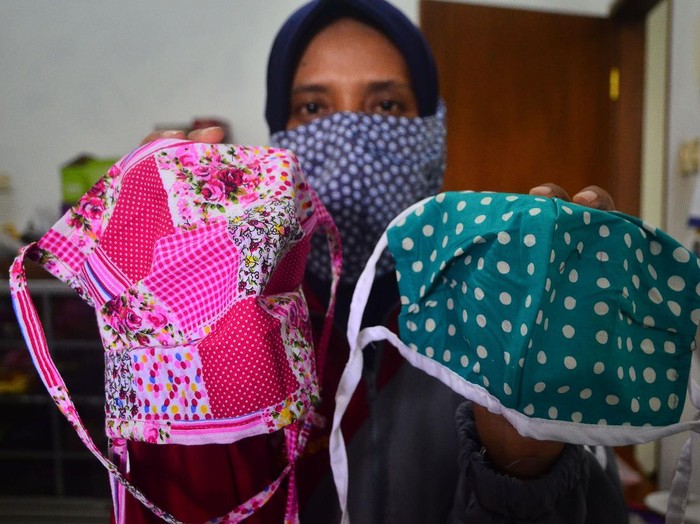 Relawan menunjukkan masker hasil produksinya di Gondangmanis, Kudus, Jawa Tengah, Senin (6/4/2020). Masker yang diproduksi dari bahan kain perca tersebut akan didistribusikan secara gratis kepada masyarakat yang membutuhkan guna mencegah penyebaran COVID-19. ANTARA FOTO/Yusuf Nugroho/wsj.