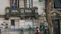 Terlihat pria paruh baya bermain biola dari balkon rumahnya sesaat pengantar paket lewat rumahnya di Rio de Janeiro, Brazil. (REUTERS/Ricardo Moraes)