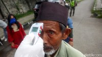 Petugas medis Kabupaten Sumedang melakukan pemeriksaan skrining (suhu tubuh)  terhadap penumpang yang berasal dari luar kota di Posko Pemeriksaan COVID-19 di Jalan Ir. Soekarno (Jalan Raya Jatinangor), Kabupaten Sumedang, Jawa Barat, Selasa (7/4/2020).