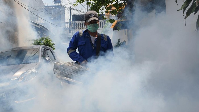 Warga menutup wajahnya dengan kaos saat berlangsungnya pengasapan (fogging) di kawasan Pasar baru, Jakarta, Selasa (7/4/2020). Kegiatan tersebut guna memberantas nyamuk Aedes aegypti sekaligus mencegah wabah demam berdarah dengue (DBD). ANTARA FOTO/M Risyal Hidayat/foc.