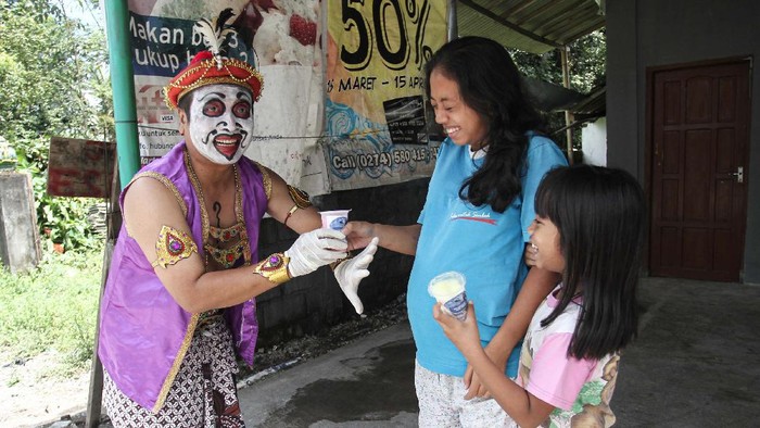 Warga mengenakan pakaian tokoh wayang punokawan membagikan susu gratis di Desa Boyong, Hargobinangun, Pakem, Sleman, DI Yogyakarta, Selasa (7/4/2020). Paguyuban Peternak Sapi Perah Boyong di lereng Gunung Merapi membagikan 2.000 cup susu gratis sebagai bentuk kepedulian kepada warga untuk meningkatkan kesehatan saat pandemi COVID-19. ANTARA FOTO/Hendra Nurdiyansyah/foc.